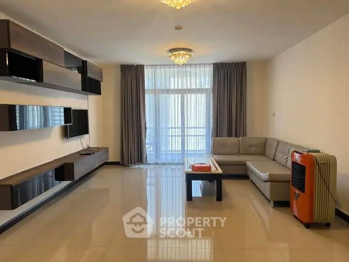 Spacious modern living room with sleek furniture and large windows.