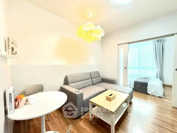 Modern living room with cozy sofa and stylish decor adjacent to a bright bedroom.