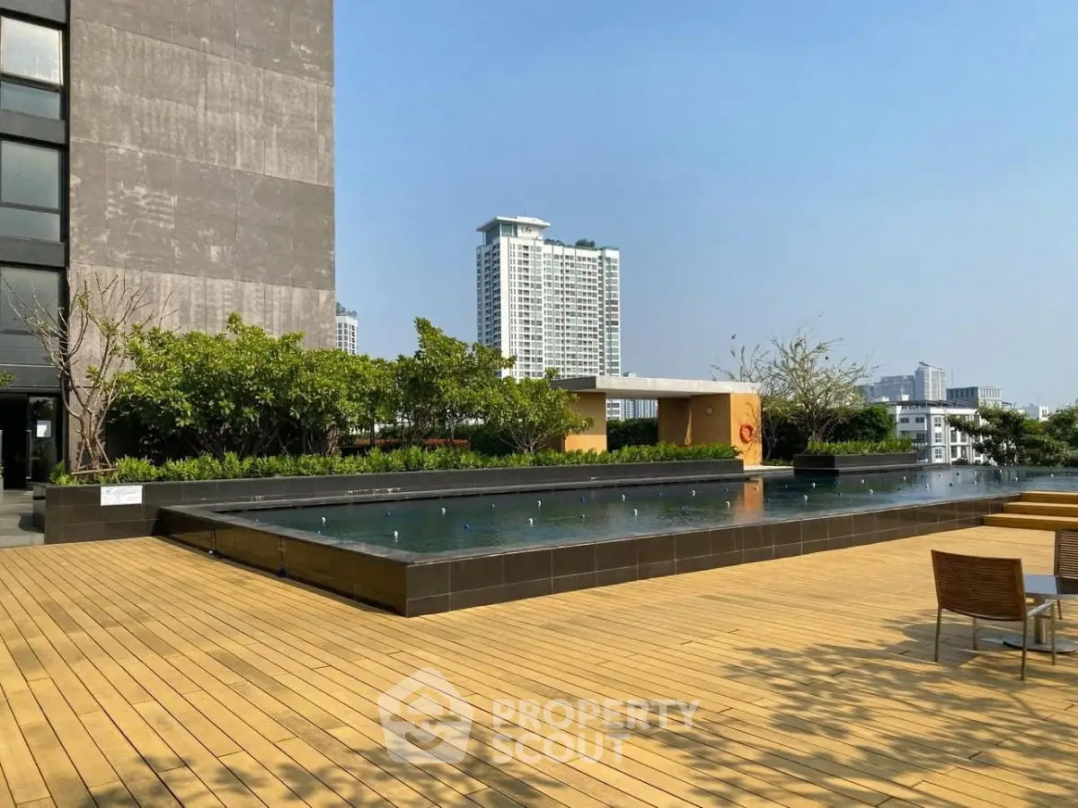 Luxurious rooftop pool with city skyline views and spacious wooden deck.