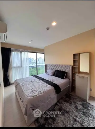 Luxurious bedroom with plush bed and city view in modern apartment