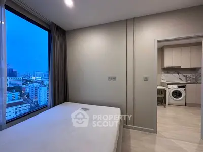 Modern apartment bedroom with city view and in-unit laundry