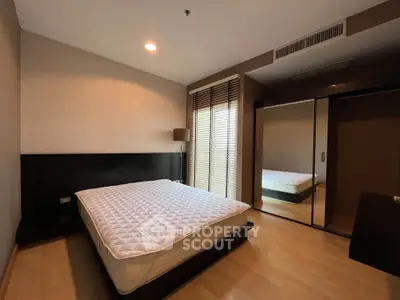 Spacious bedroom with large window and modern design in a luxury apartment.