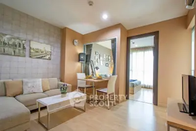 Modern living room with cozy seating and stylish decor, adjacent to a bright bedroom.