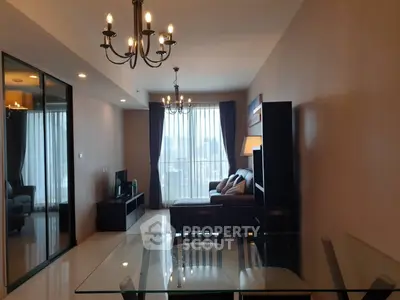 Spacious modern living room with elegant chandeliers and large windows offering natural light.