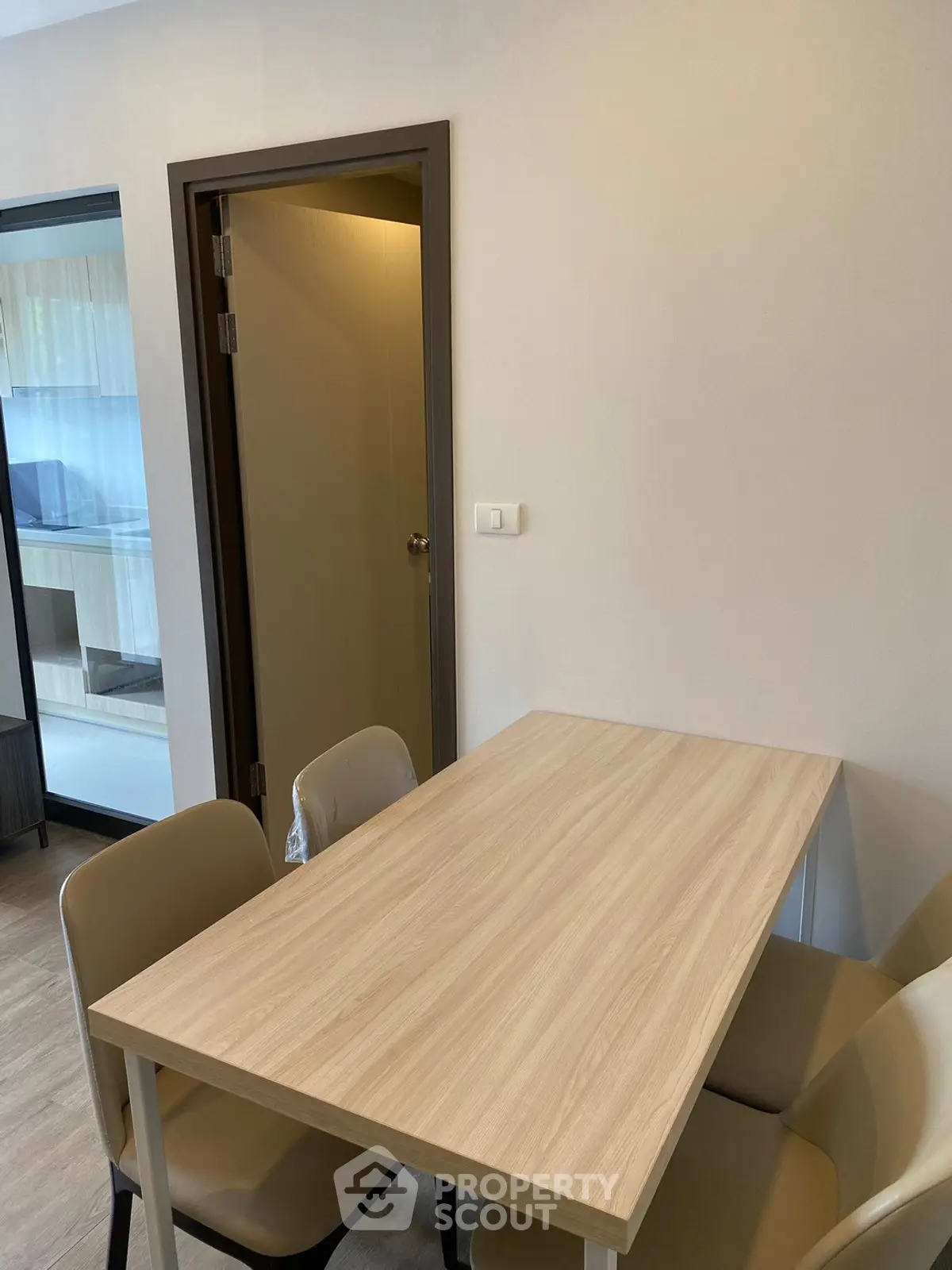Modern dining area with wooden table and chairs in a cozy apartment setting.