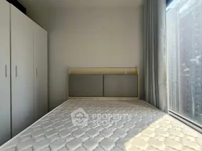Bright bedroom with large window and modern wardrobe