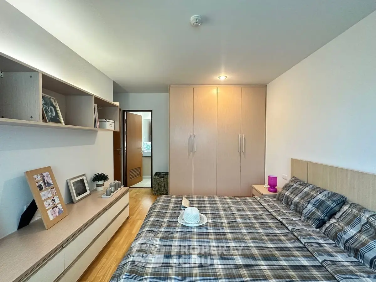 Cozy bedroom with plaid bedding and ample storage in modern apartment