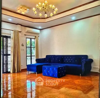 Elegant living room with plush blue sofa and chandelier lighting