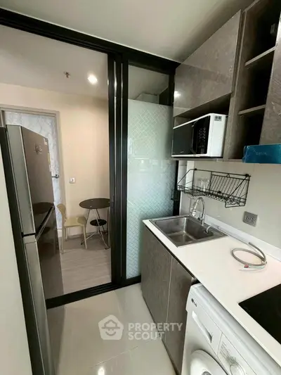 Modern kitchen with sleek appliances and dining area in compact layout