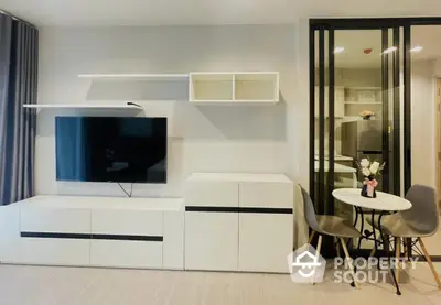 Modern living room with sleek TV unit and stylish dining area in contemporary apartment.