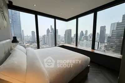 Luxurious bedroom with panoramic city view in modern high-rise apartment.