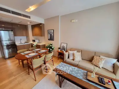 Modern living room with open kitchen, stylish decor, and cozy seating area.