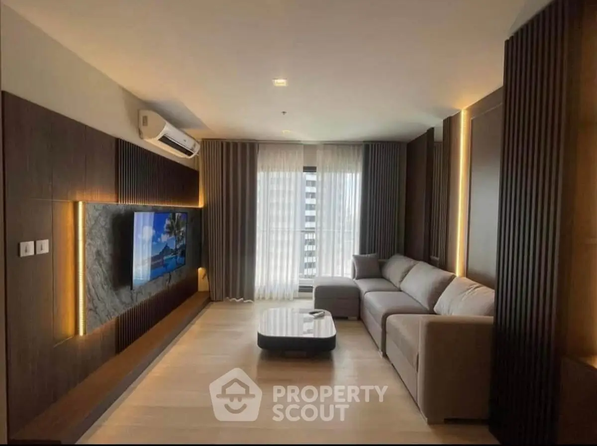 Luxurious modern living room with sleek design and large TV, perfect for relaxation.