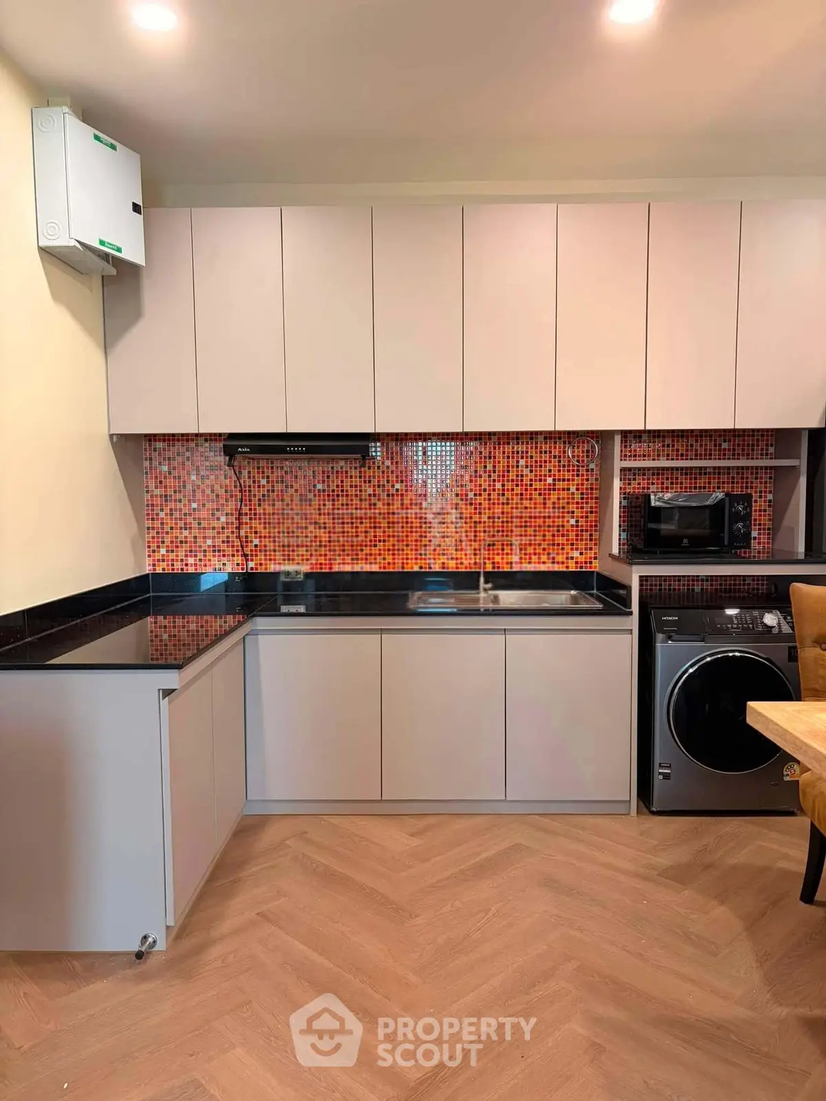 Modern kitchen with sleek cabinetry, vibrant orange backsplash, and integrated appliances.