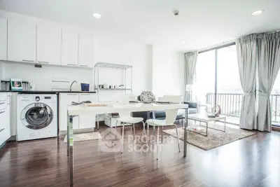 Modern open-plan kitchen and living area with natural light and balcony access.