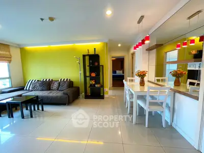 Modern living room with stylish decor and dining area, featuring bright lighting and contemporary furniture.