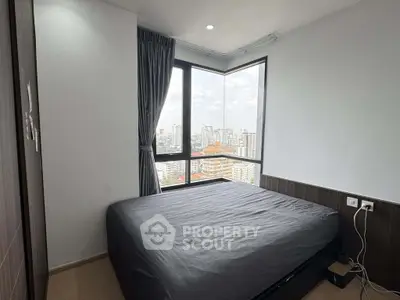 Modern bedroom with panoramic city view and sleek design in high-rise apartment.