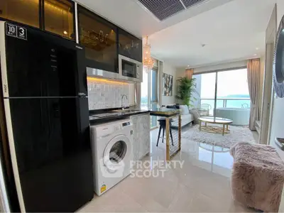 Luxurious open-plan living room with modern kitchen and stunning sea view balcony.