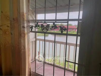 Charming balcony view overlooking serene water and lush greenery, perfect for relaxation.