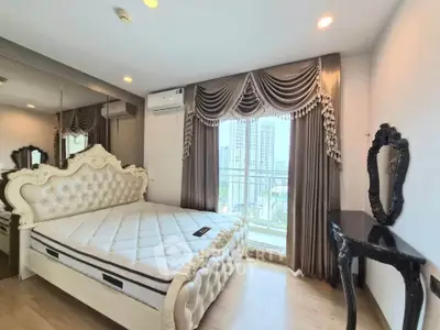 Luxurious bedroom with elegant decor and city view, featuring ornate bed and stylish curtains.