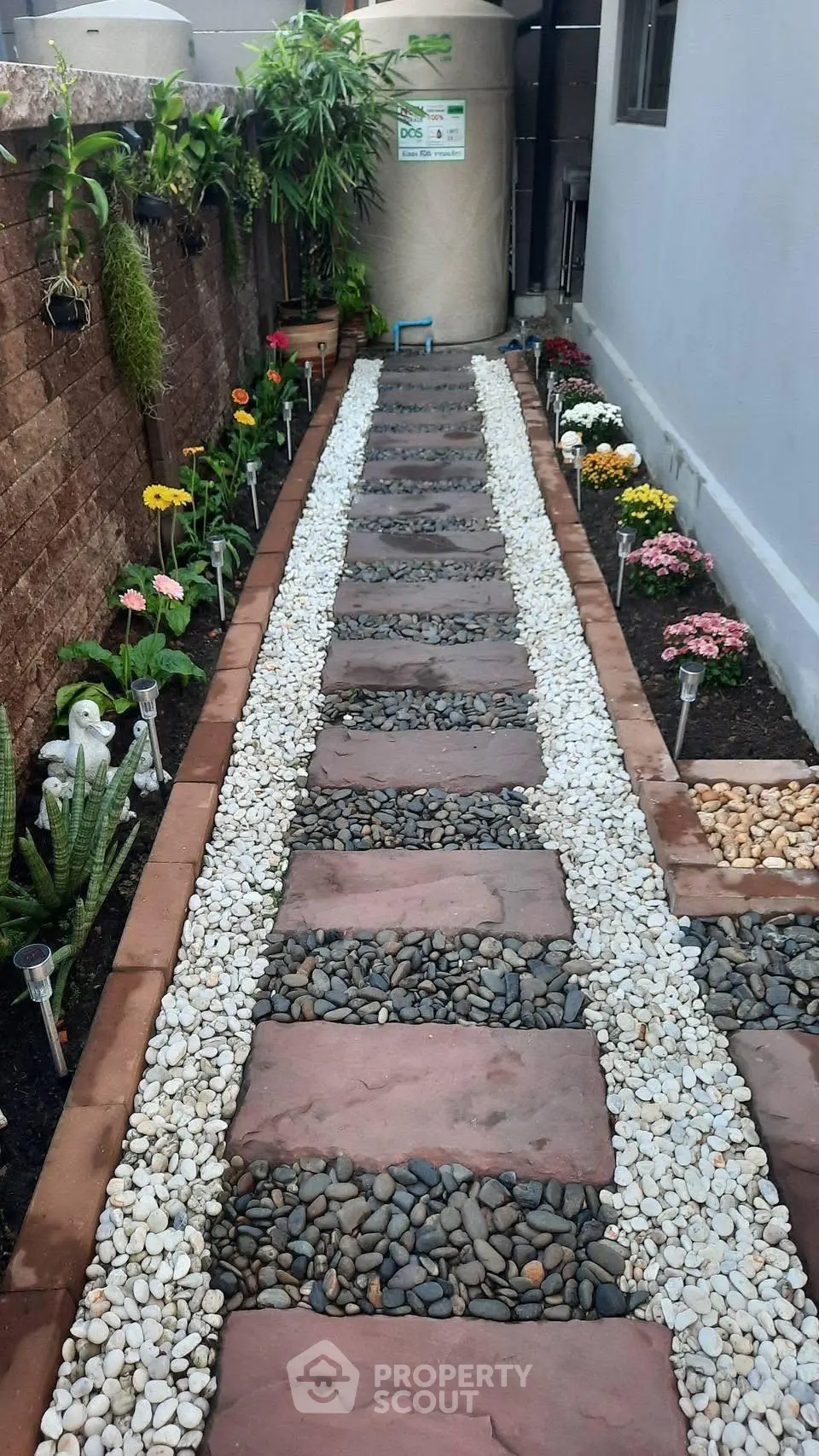 Charming garden pathway with decorative stones and vibrant flowers, perfect for enhancing curb appeal.