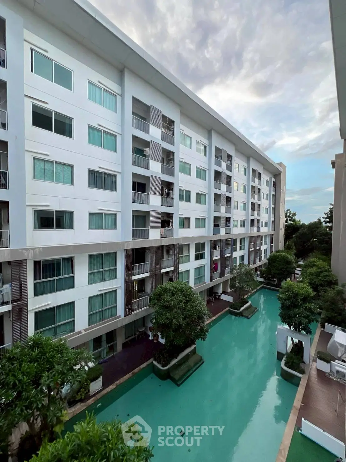 Modern condominium with pool view and lush greenery, perfect for urban living.