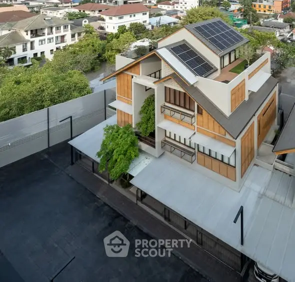 Modern eco-friendly building with solar panels and lush greenery in urban setting.