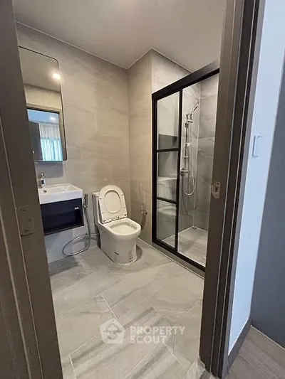 Modern bathroom with sleek shower and elegant fixtures in contemporary apartment.