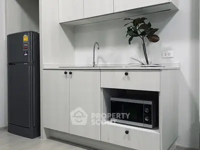 Modern kitchen with sleek cabinetry, built-in microwave, and energy-efficient refrigerator.