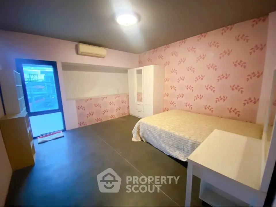 Spacious bedroom with pink floral wallpaper and modern furnishings