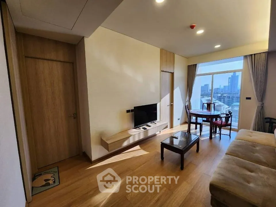 Modern living room with city view, wooden flooring, and stylish furniture in a high-rise apartment.