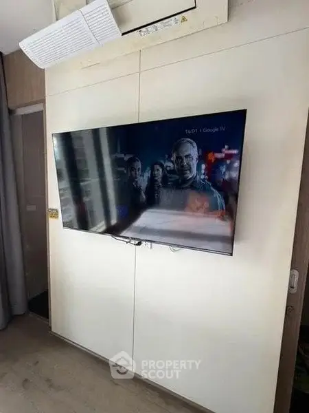 Modern living room with wall-mounted TV and sleek air conditioning unit.