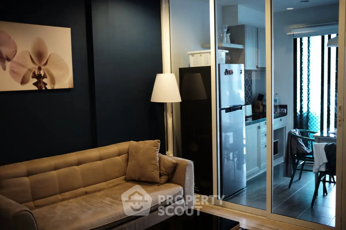 Modern living room with cozy sofa and stylish kitchen in open layout apartment.