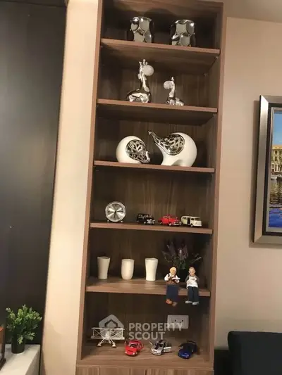 Stylish wooden shelf with decorative items in modern living room interior.