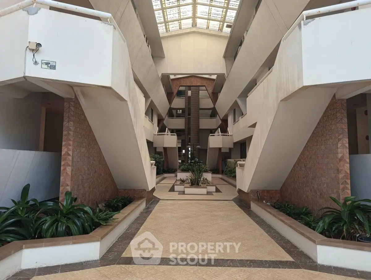 Stunning modern building entrance with unique architectural design and lush greenery.