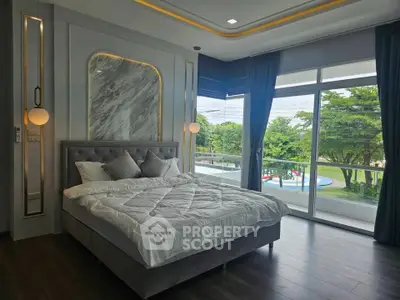 Luxurious bedroom with elegant decor and large windows offering a serene view of greenery.