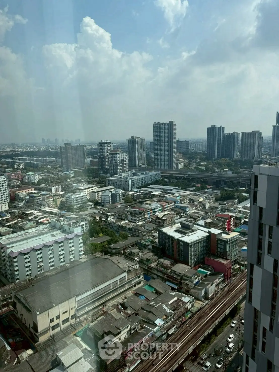 Stunning cityscape view from high-rise building showcasing urban skyline and residential areas.