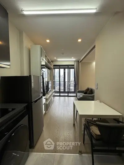 Modern living room with balcony view, sleek furniture, and open layout in a high-rise apartment.
