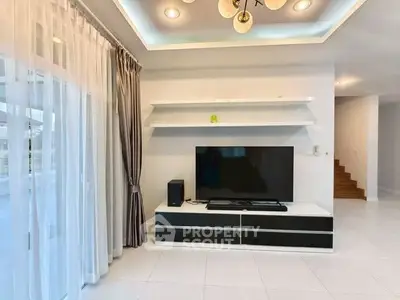 Modern living room with sleek TV setup and elegant lighting, perfect for entertainment.
