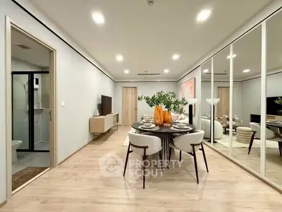 Modern open-plan living and dining area with elegant decor and mirrored walls