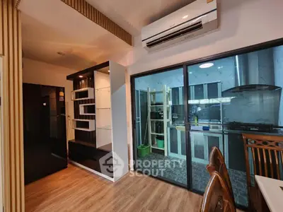 Modern kitchen with sleek appliances and open layout, featuring air conditioning and stylish wooden flooring.