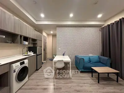 Modern open-layout living room with stylish furniture and in-unit washing machine, perfect for urban living.