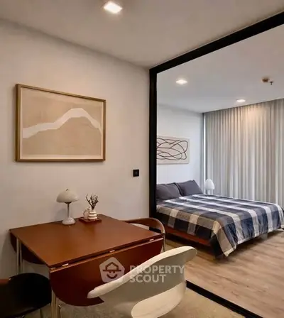 Modern bedroom with stylish decor and cozy study area, featuring elegant furnishings and contemporary artwork.