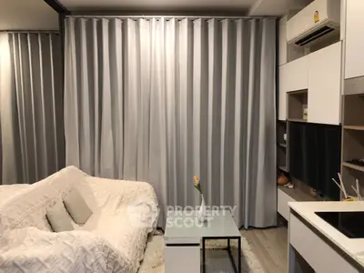 Modern living room with cozy sofa, sleek curtains, and compact kitchen area.