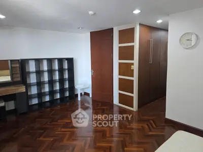 Spacious room with wooden flooring and modern storage solutions