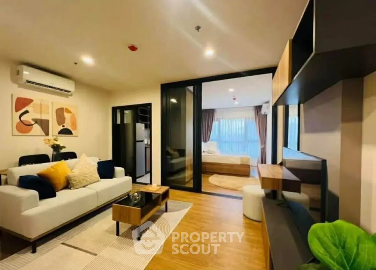 Modern living room with stylish decor and open view to bedroom