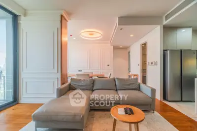 Luxurious modern living room with elegant sofa and dining area, featuring large windows and stylish decor.