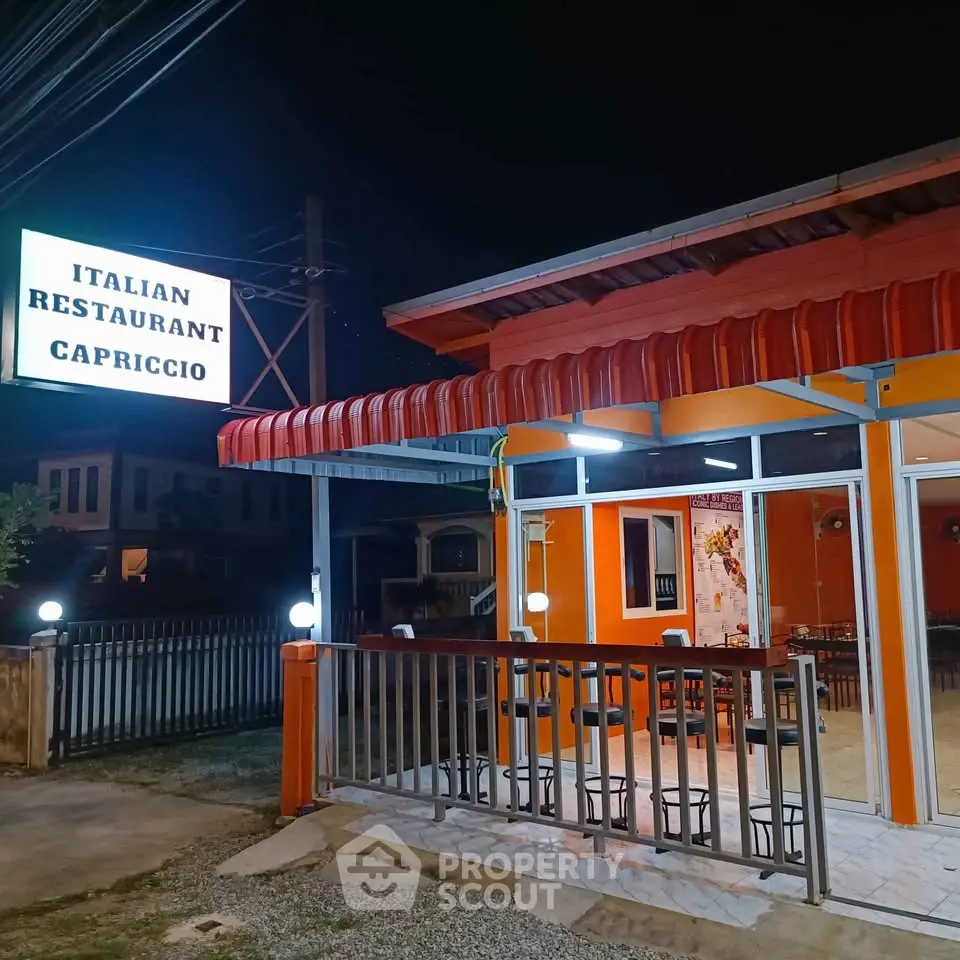 Charming Italian restaurant exterior with inviting night ambiance and vibrant orange facade.