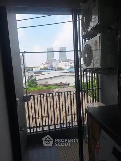 Charming balcony view with cityscape and modern appliances, perfect for urban living.