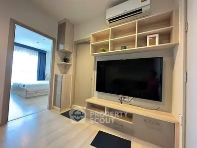Modern living room with sleek TV unit and air conditioning, adjacent to a cozy bedroom.